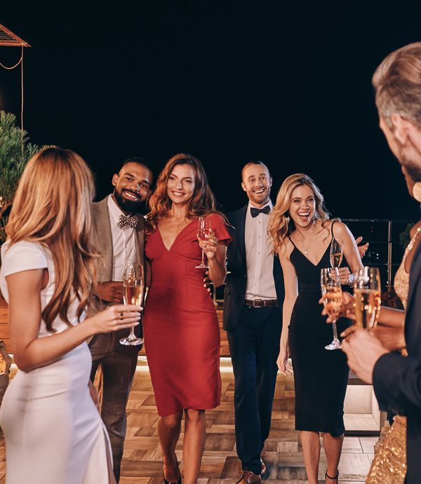 Group of beautiful people in formalwear communicating and smiling while spending time on luxury party